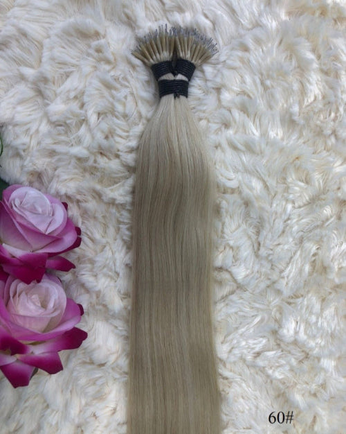Close-up of nano tip hair extensions showing tiny metal loop bonds.