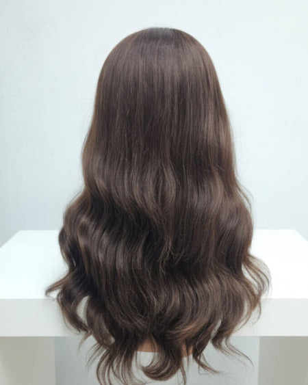 Back view of a full density Body Wave Wig with Bangs. Long, wavy strands.