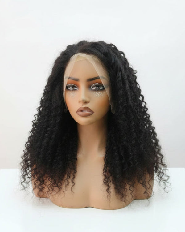 Stylist finger-combing defined short tight curls on a human hair pixie wig.